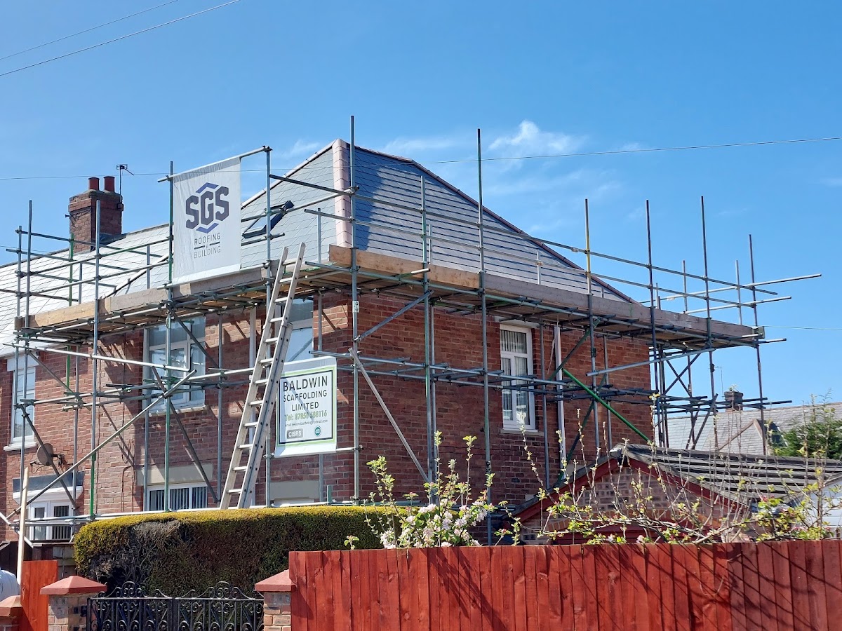 A scaffolded semi in North Shields with a new slate roof and the SGS Roofing and Building banner on the scaffold